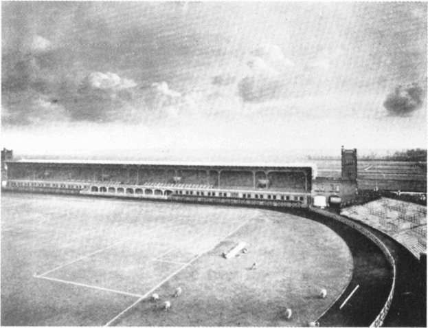 Schwarzes und weißes Foto eines Fußballfeldes mit einem Stadion, das von Bäumen umgeben ist und von einem bewölkten Himmel, beschriftet mit "Stoke City Football Club" unten.