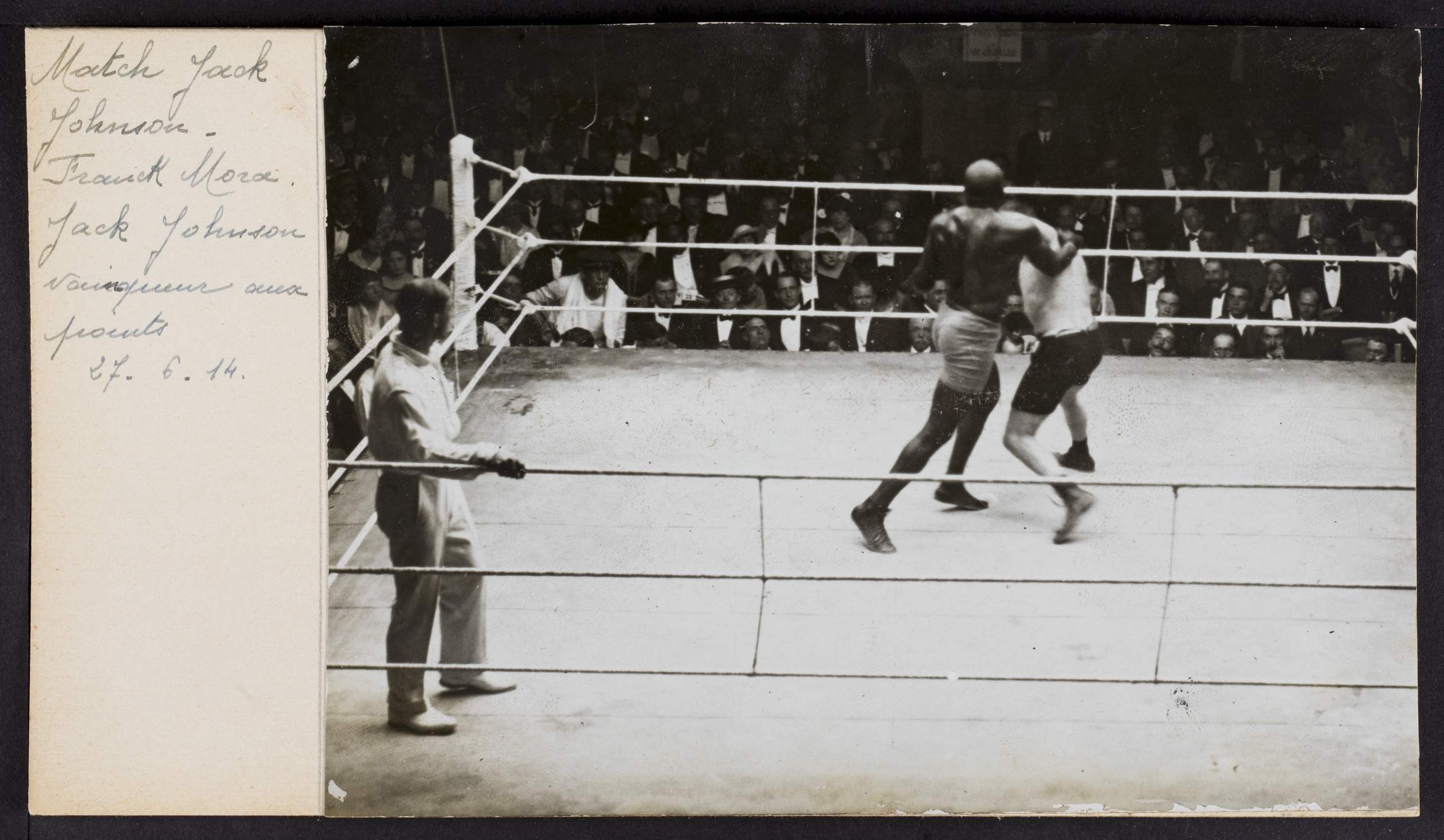 Schwarzes und weißes Foto von zwei Boxern in einem Ring mit einem Schiedsrichter und Zuschauern, betitelt mit "Jack Johnson vs Frank Morgan".
