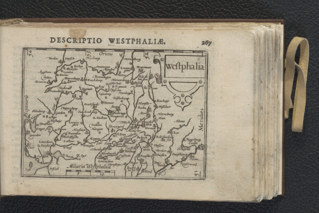 Offenes Buch mit einer detaillierten Karte von Westfalen auf einer schwarzen Oberfläche.