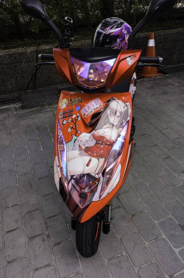 Ein oranges E-Scooter auf dem Straßenrand mit einem Helm darauf, mit einer Verkehrskegel, einer Wand und mehreren Bäumen im Hintergrund.