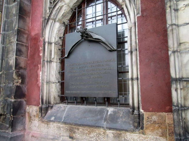 Steinbau mit Fenster und einer Holocaust-Gedenktafel mit Inschrift