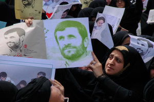 Eine Gruppe iranischer Frauen in schwarzer Kleidung, einige mit Brille, halten Bilder von Präsident Mahmoud Ahmadinejad während einer Demonstration in Tehran hoch.