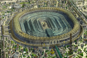 Luftaufnahme eines großen Stadions umgeben von Gebäuden, Bäumen und Gras in einer städtischen Umgebung.