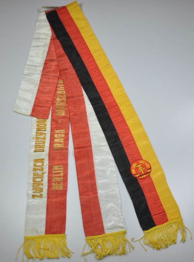 Ein gestreifter Schal mit dem Logo der deutschen Nationalmannschaft auf einer weißen Oberfläche.