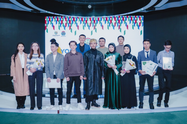 Gruppe von Menschen auf einer Bühne mit Blumensträuseln und Urkunden, mit einem "Jugend-Solar-Awards 2019"-Hintergrund.